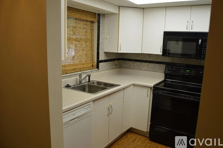 A kitchen with white cabinets and a black oven.