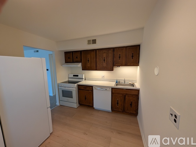 A kitchen with wooden cabinets and white appliances.