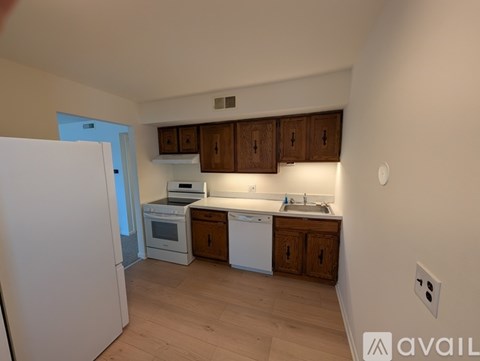 A kitchen with wooden cabinets and white appliances.