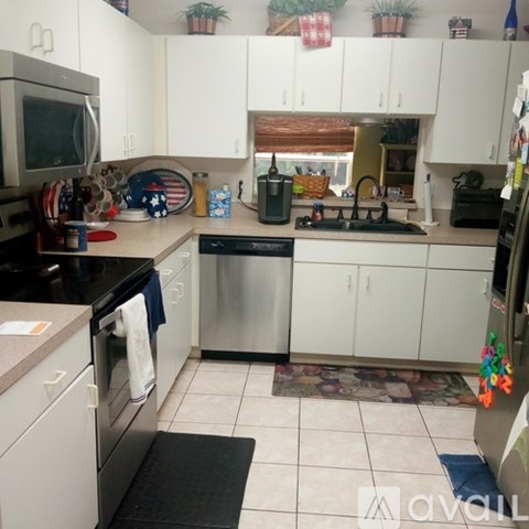A kitchen with white cabinets and a black dishwasher.