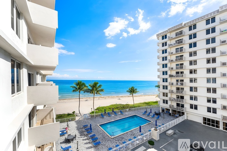 A view of a pool area from a high-rise building overlooking the beach.