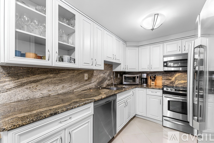 A kitchen with white cabinets and granite countertops.