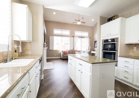 A kitchen with white cabinets and a marble countertop.