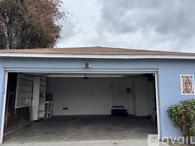A garage with a white interior and a blue exterior wall.