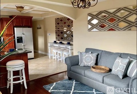 A living room with a grey couch and a white chair.