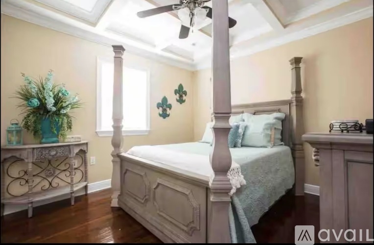 A bedroom with a large bed and a ceiling fan.