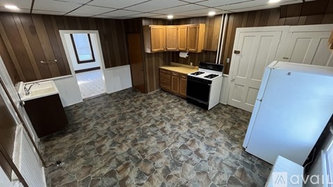 A kitchen with a stove top oven and a refrigerator.
