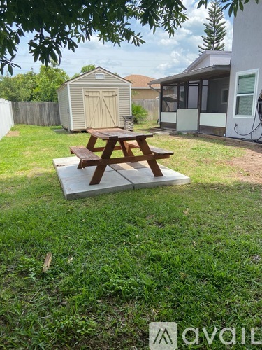 A picnic table is on a concrete slab in a backyard.