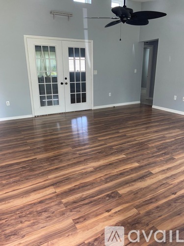 A room with wooden flooring and a ceiling fan.