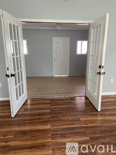 A room with wooden floors and two white doors.