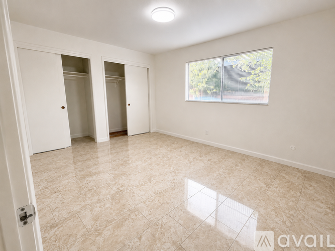 A room with a tiled floor and a window showing trees outside.