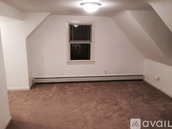 A room with a window and carpeted floor.