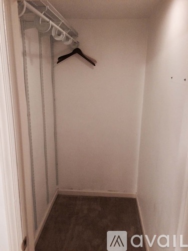 A small closet with a hanger on the rail.