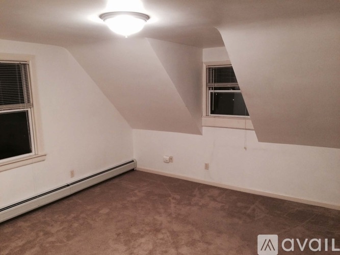 A room with a window and a carpeted floor.