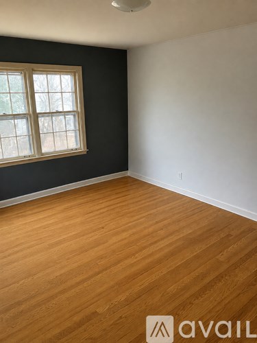 A room with wooden flooring and a window.
