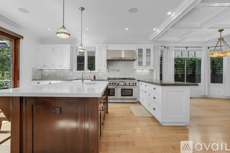 A modern kitchen with white cabinets and a wooden island.