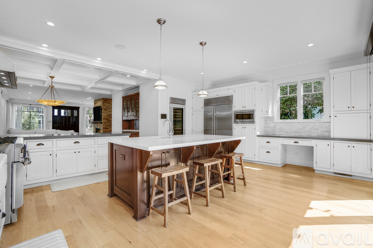 A kitchen with white cabinets and a wooden island.