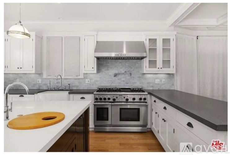 A kitchen with white cabinets and a stainless steel stove.