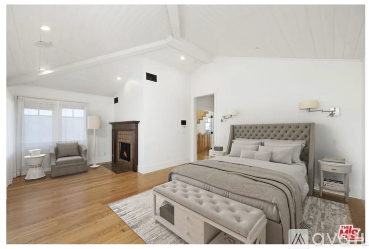 A bedroom with a large bed and a fireplace.