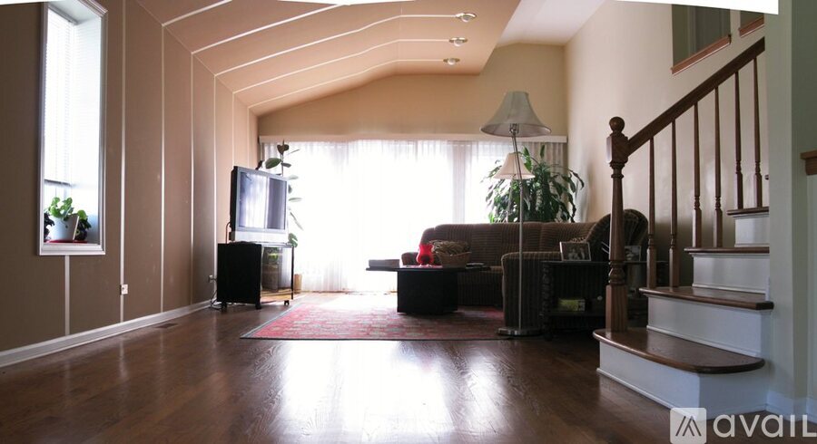 A living room with a couch, a television, and a plant.