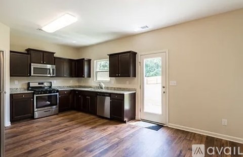 A kitchen with dark wood cabinets and a white door.