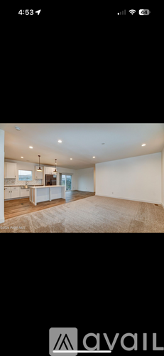 A room with a large open space and a kitchen area.