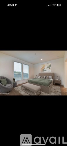 A bedroom with a bed, a chair, and a window.