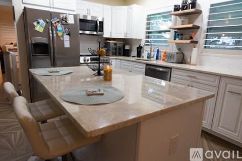 A kitchen with a table and a refrigerator.