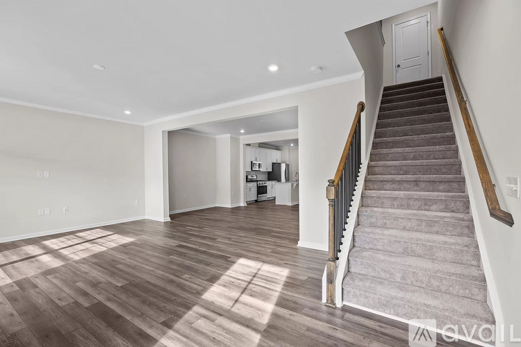 A spacious room with a staircase leading to the upper floor.