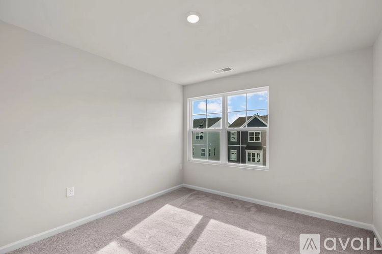 A room with a window showing a view of houses outside.