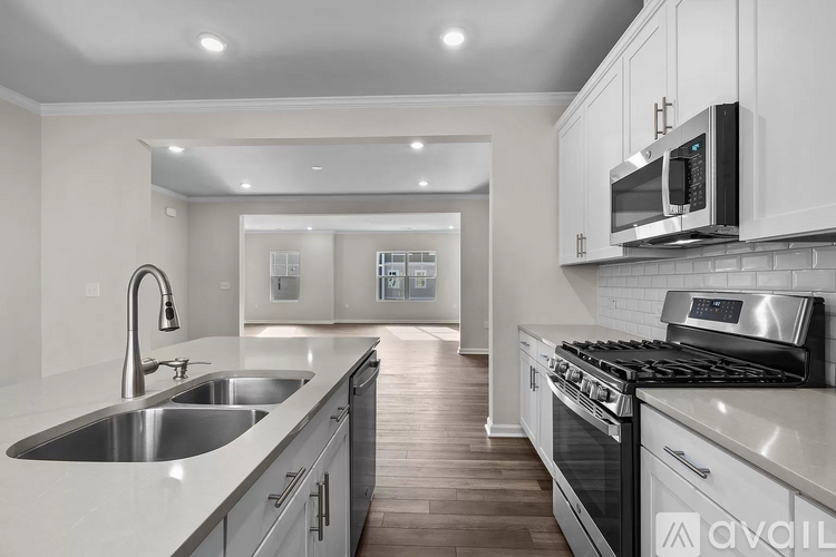 A modern kitchen with a stainless steel sink and oven.