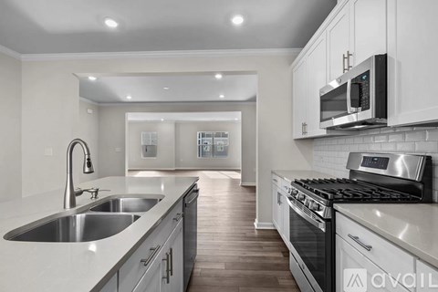 A modern kitchen with a stainless steel sink and oven.