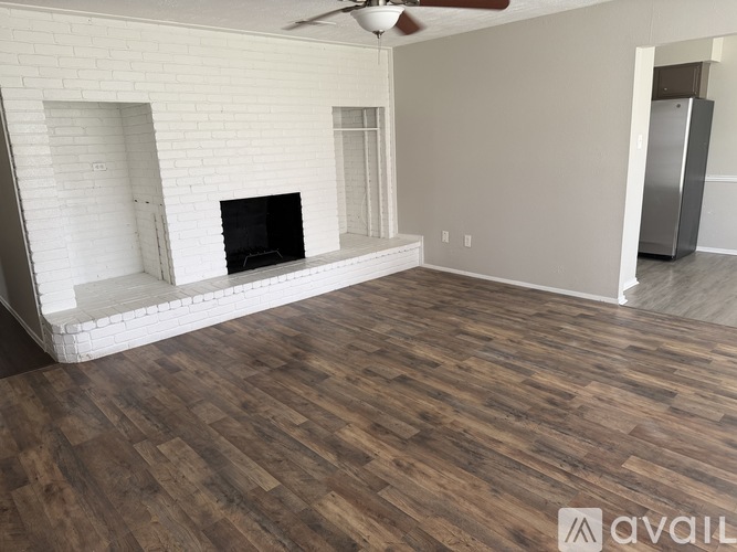 A living room with a fireplace and a wooden floor.