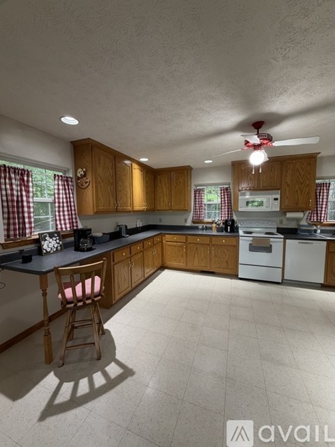 A kitchen with wooden cabinets and a white dishwasher.