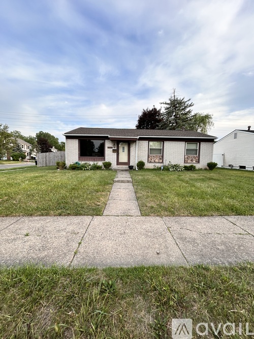 A house with a white fence and a brown roof is in the image.