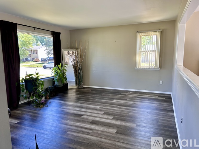 A room with wooden flooring and a window with blinds.