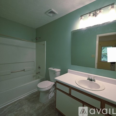 A bathroom with green walls and a white toilet.