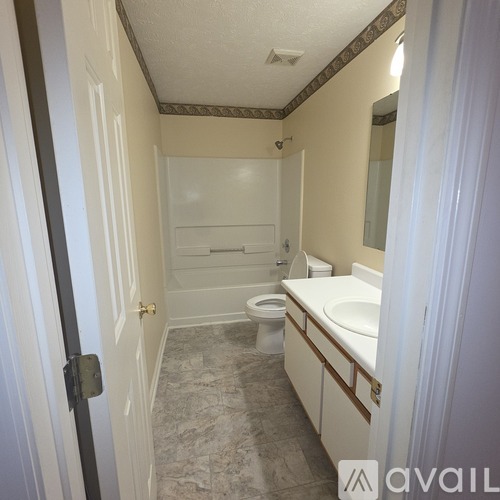 A bathroom with a toilet, sink, and shower.