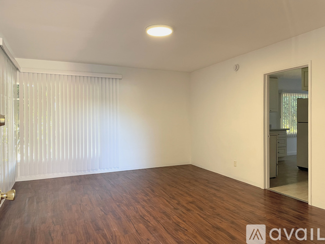 A room with wooden flooring and a sliding glass door.