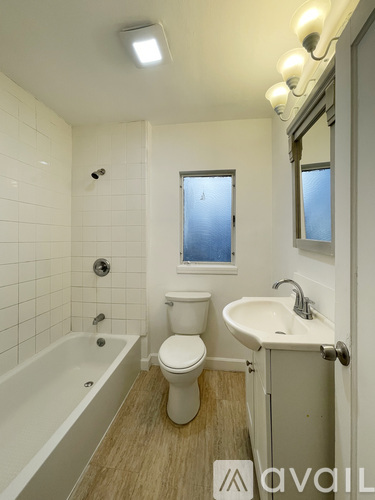 A bathroom with a toilet, sink, and bathtub.