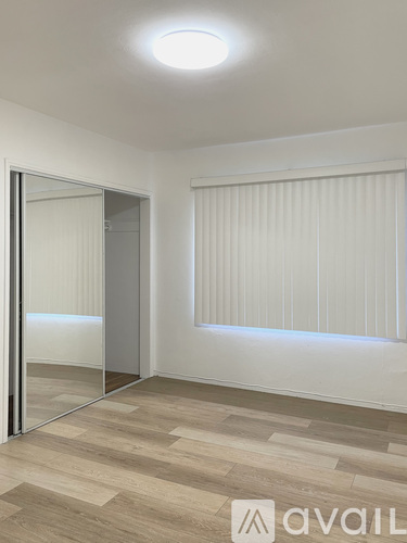 A room with a wooden floor and a wall with horizontal lines.