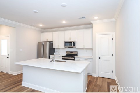 A kitchen with white cabinets and appliances.