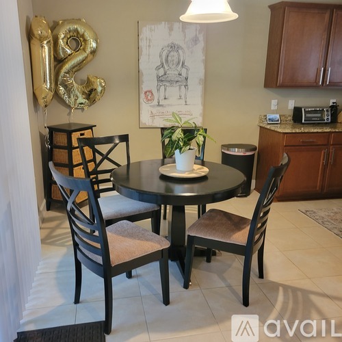 A dining room with a round table and chairs.