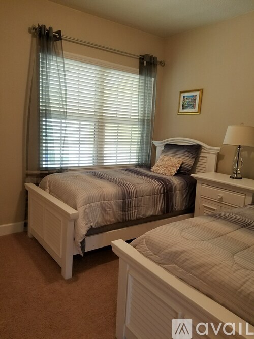 A bedroom with a large bed and a smaller bed in the corner.