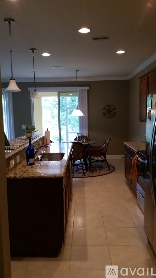 A kitchen with a granite countertop and a dining table with chairs.