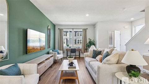 A living room with a white couch, a coffee table, and a painting on the wall.