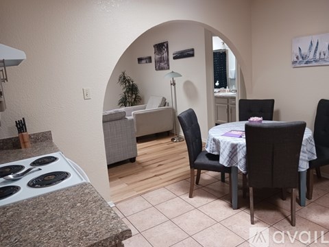 A kitchen area with a table and chairs set up.