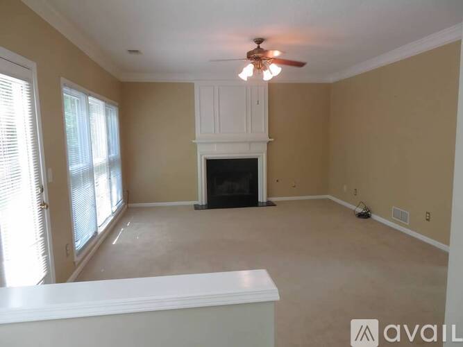 A living room with a fireplace and a ceiling fan.