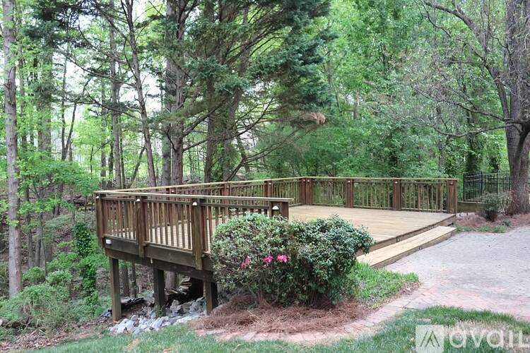 A wooden deck surrounded by greenery and trees.
