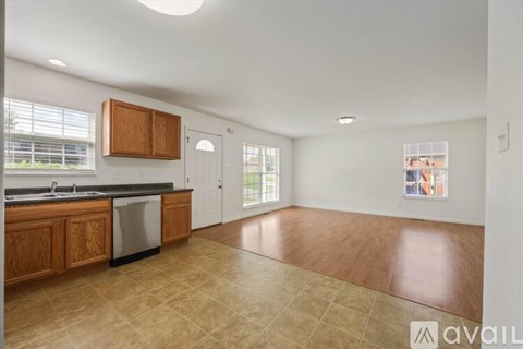 A kitchen with wooden cabinets and a black countertop is available for rent.